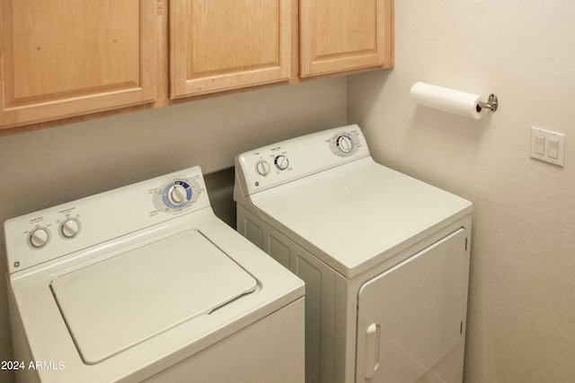 laundry area with washer and dryer and cabinets