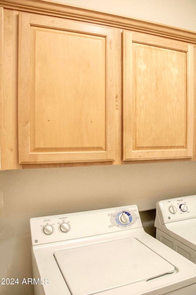 laundry room featuring cabinets and washer and clothes dryer