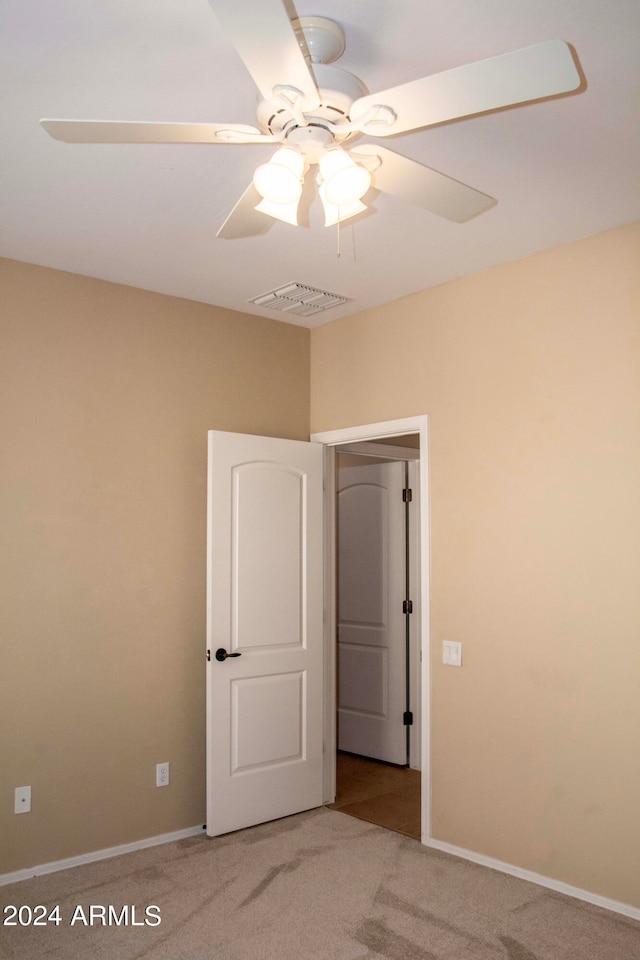 carpeted spare room featuring ceiling fan