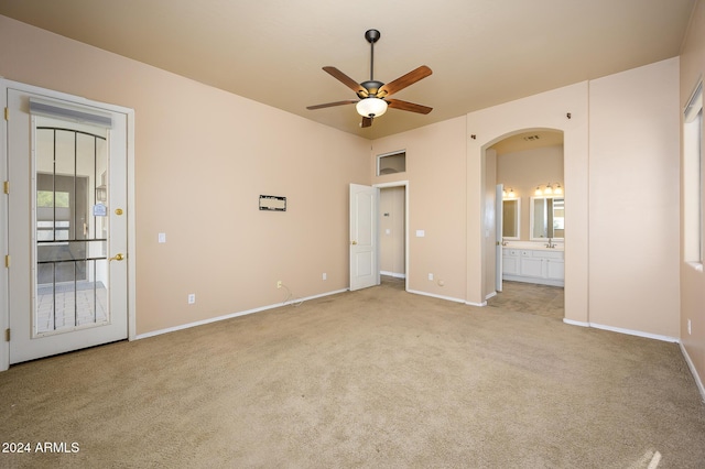 unfurnished bedroom with light carpet, ensuite bath, ceiling fan, and sink