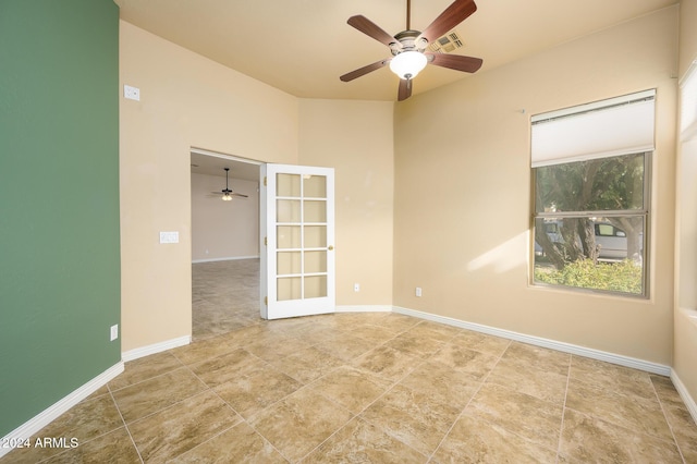 empty room featuring ceiling fan and french doors