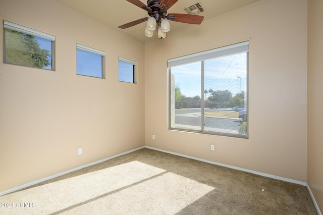 carpeted spare room with ceiling fan