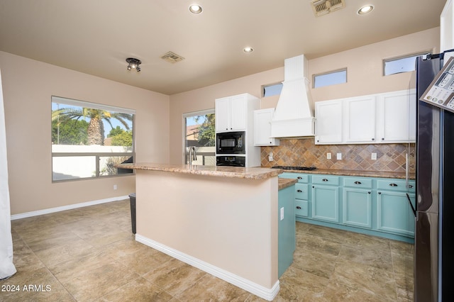 kitchen featuring white cabinets, custom range hood, a kitchen island, and black appliances