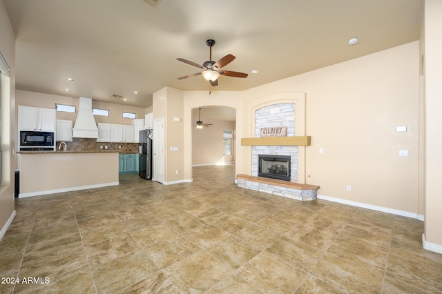 unfurnished living room featuring a fireplace and ceiling fan