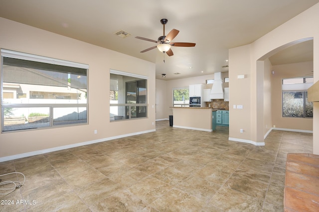 unfurnished living room featuring ceiling fan