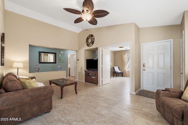 living room with baseboards, vaulted ceiling, and a ceiling fan