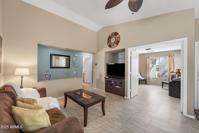 living room with ceiling fan, baseboards, and vaulted ceiling