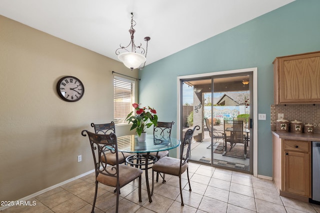 dining area with light tile patterned flooring, vaulted ceiling, and baseboards