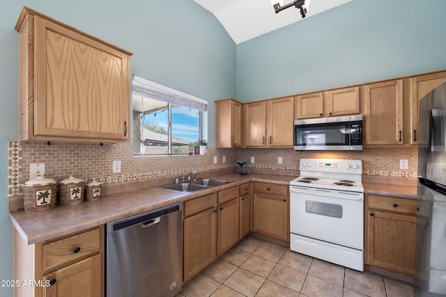 kitchen with light tile patterned floors, stainless steel appliances, tasteful backsplash, and a sink