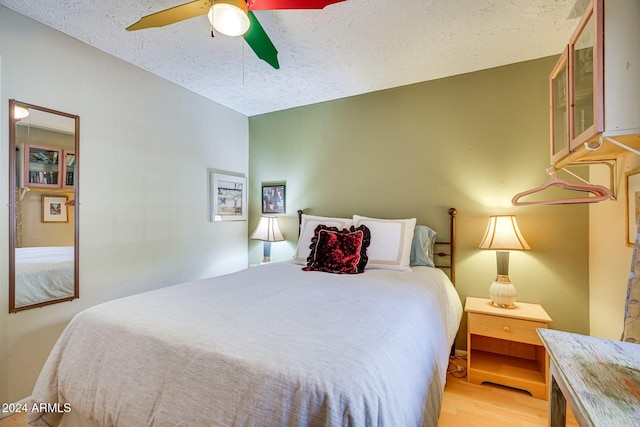bedroom featuring a textured ceiling, a ceiling fan, and light wood-type flooring
