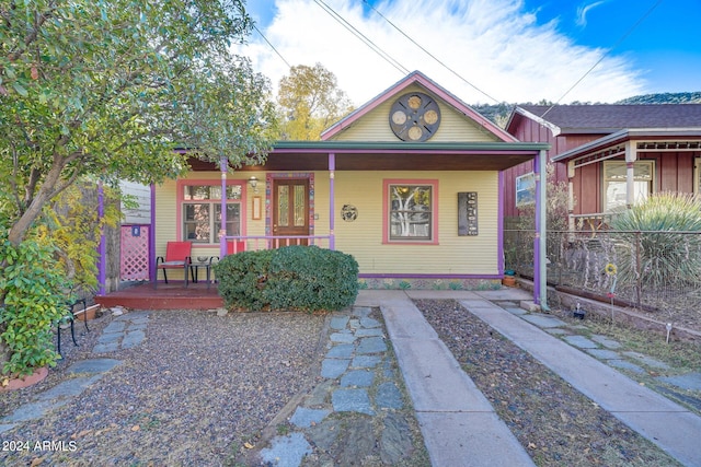 bungalow with a porch and fence