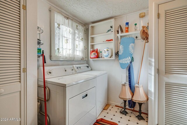 laundry area featuring separate washer and dryer, laundry area, a textured ceiling, light floors, and baseboards