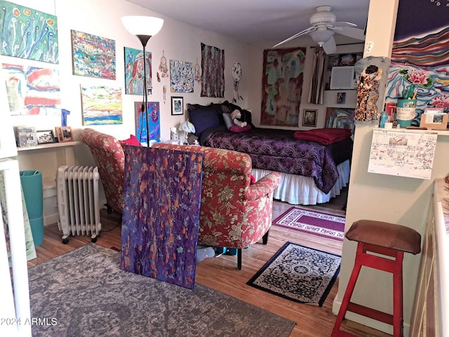 bedroom featuring wood finished floors and radiator heating unit