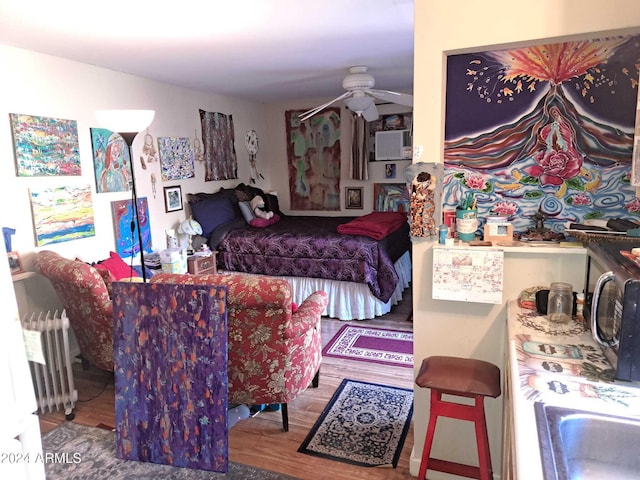 bedroom featuring wood finished floors and radiator heating unit