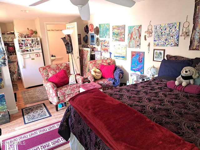 bedroom featuring freestanding refrigerator, wood finished floors, and ceiling fan