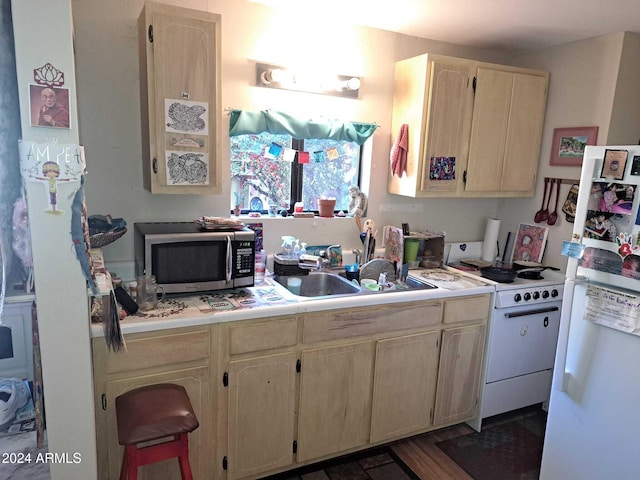 kitchen with light countertops, a sink, and white appliances