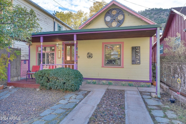 view of front facade featuring covered porch and fence