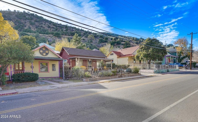 view of front of house featuring a porch, fence private yard, and a mountain view