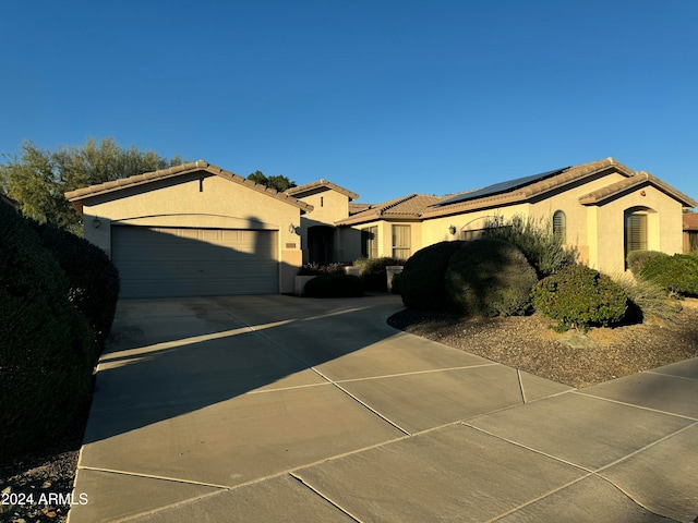 view of property exterior with a garage and solar panels