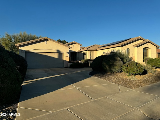 view of property exterior with a garage and solar panels