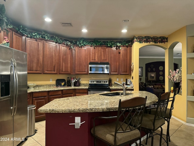 kitchen featuring a kitchen island with sink, crown molding, sink, light tile patterned flooring, and stainless steel appliances