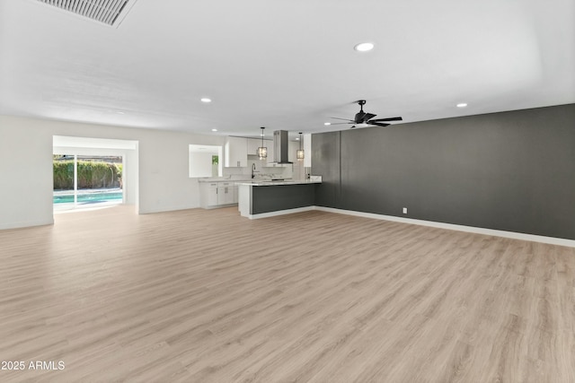 unfurnished living room featuring light wood-type flooring and ceiling fan