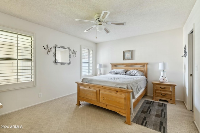 bedroom with ceiling fan and a textured ceiling