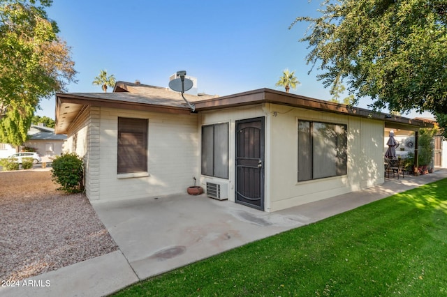 rear view of house featuring a lawn and a patio area