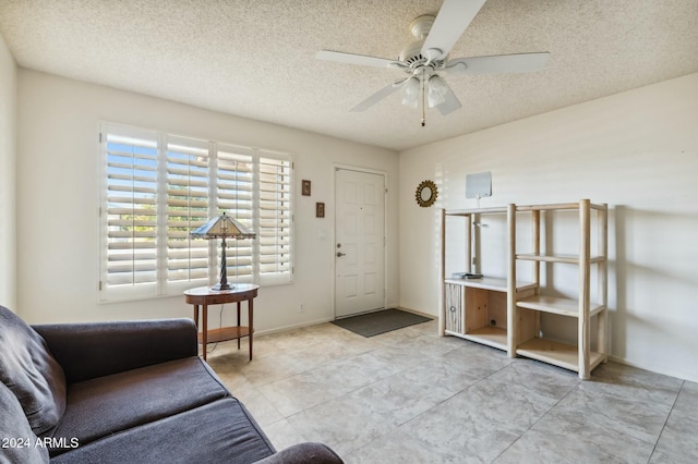 interior space with ceiling fan and a textured ceiling