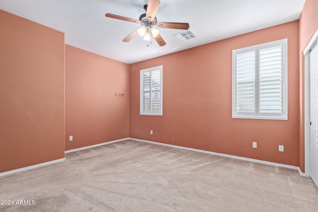 empty room with light colored carpet and ceiling fan