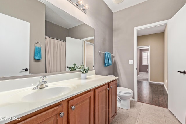 bathroom with tile patterned flooring, vanity, and toilet