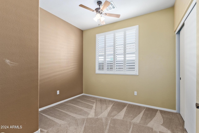 unfurnished bedroom with ceiling fan, carpet flooring, and a closet