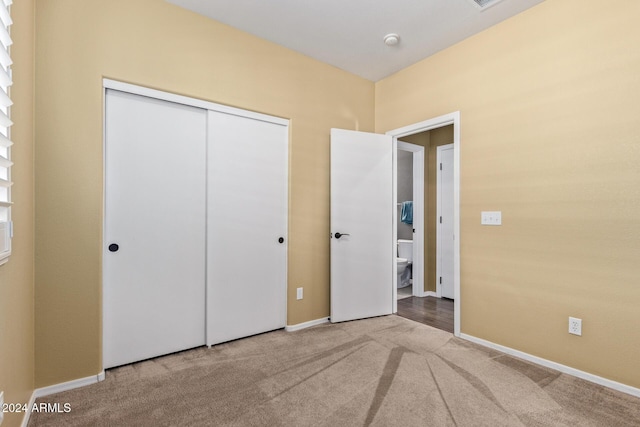 unfurnished bedroom featuring carpet flooring and a closet