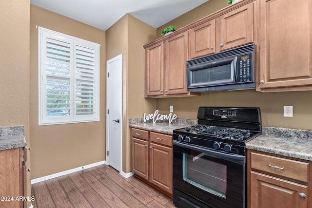 kitchen featuring hardwood / wood-style floors and black appliances