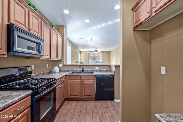 kitchen featuring sink, light hardwood / wood-style flooring, and black appliances