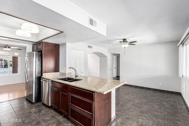 kitchen featuring ceiling fan, visible vents, appliances with stainless steel finishes, arched walkways, and a sink