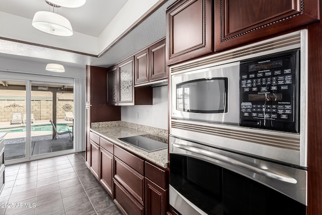 kitchen featuring light tile patterned flooring, decorative light fixtures, appliances with stainless steel finishes, and dark brown cabinets