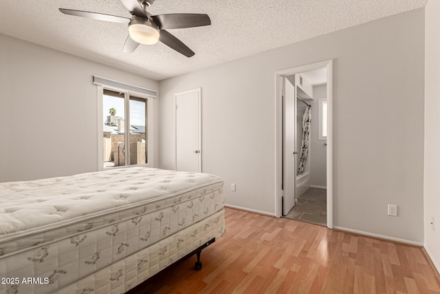 bedroom featuring a textured ceiling, access to exterior, baseboards, and light wood-type flooring