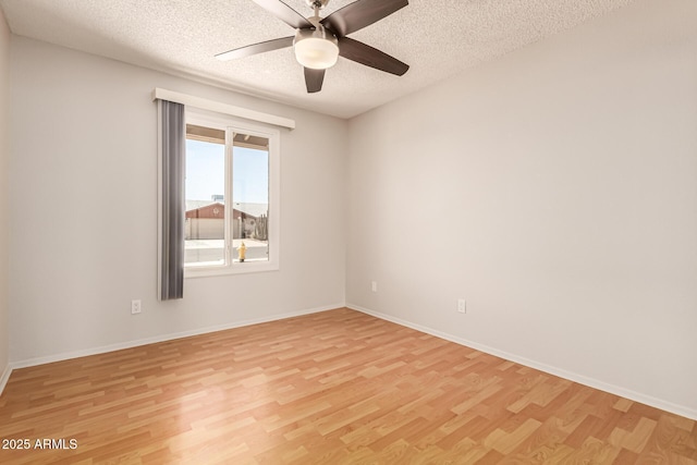unfurnished room featuring light wood-style floors, baseboards, ceiling fan, and a textured ceiling