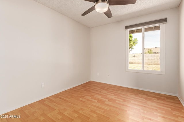 spare room with baseboards, a textured ceiling, ceiling fan, and light wood-style flooring