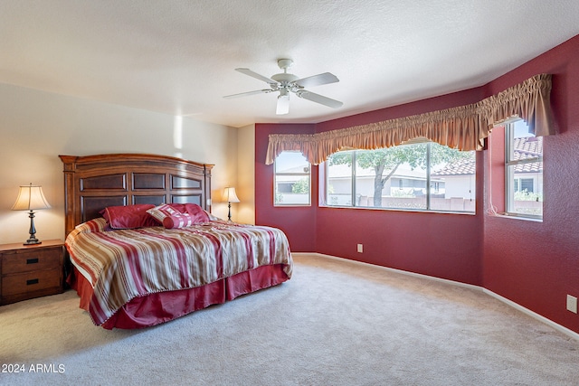 carpeted bedroom with ceiling fan and a textured ceiling