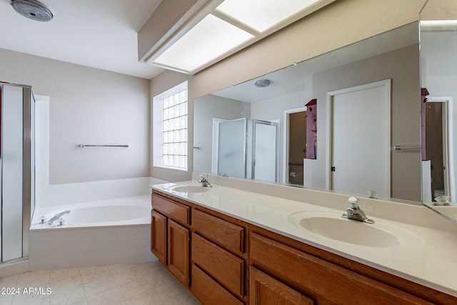 bathroom featuring vanity, a skylight, and independent shower and bath