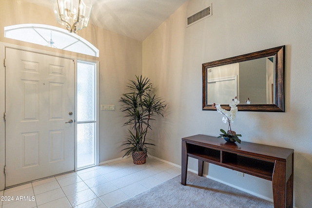 tiled entrance foyer with an inviting chandelier