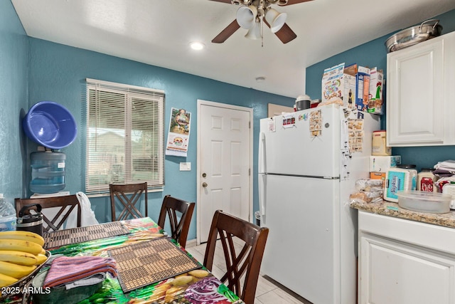 2747 E Wier Ave, Phoenix, AZ 85040 - kitchen featuring ceiling fan, light stone counters, freestanding refrigerator, white cabinetry, and light tile patterned floors