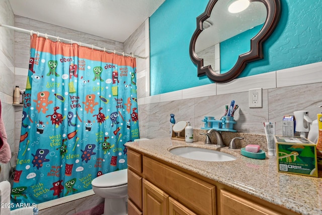 2747 E Wier Ave, Phoenix, AZ 85040 - full bath featuring vanity, toilet, curtained shower, and tile walls