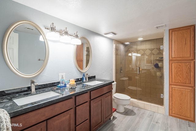 bathroom with toilet, walk in shower, hardwood / wood-style floors, vanity, and a textured ceiling