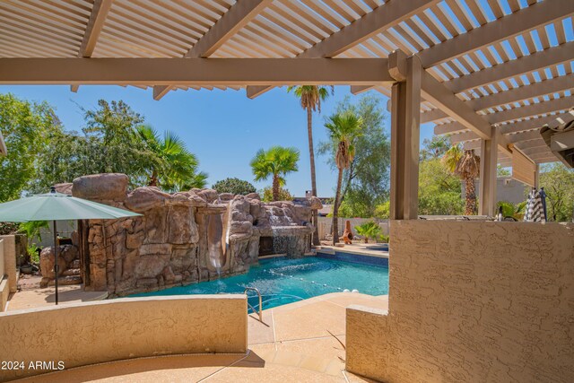 view of swimming pool with pool water feature, a pergola, and a patio