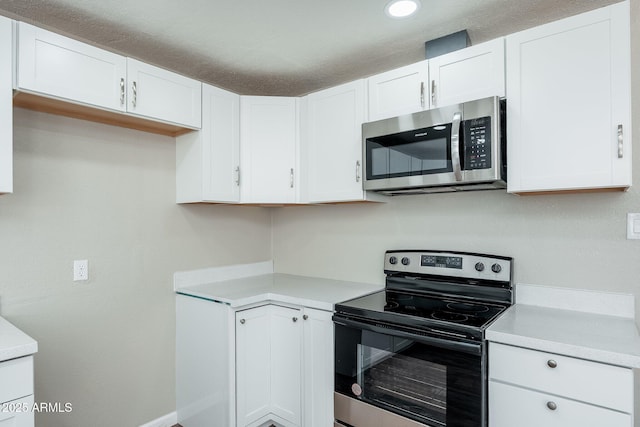 6223 W Earll Dr, Phoenix, AZ 85033 - kitchen with stainless steel microwave, electric stove, light countertops, white cabinets, and recessed lighting