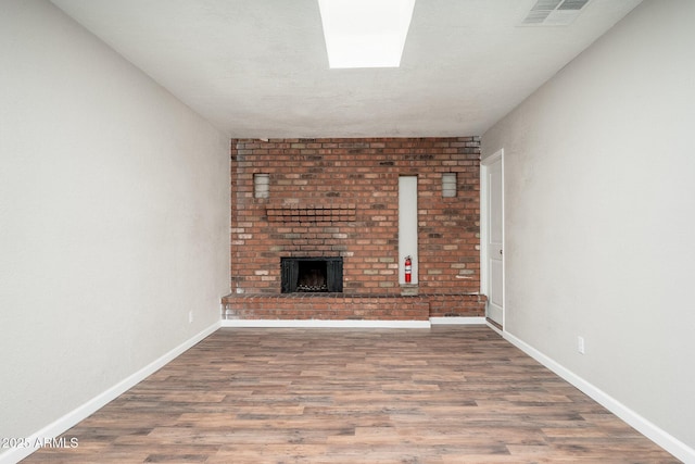 6223 W Earll Dr, Phoenix, AZ 85033 - unfurnished living room featuring a brick fireplace and wood finished floors