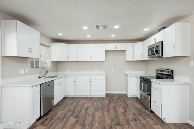 6223 W Earll Dr, Phoenix, AZ 85033 - kitchen featuring appliances with stainless steel finishes, dark wood finished floors, white cabinetry, recessed lighting, and light countertops